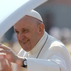 Uśmiechnięty Papież Franciszek w białej sutannie pozdrawia tłum. Choć nie zarabia, jego wpływ jest nieoceniony.