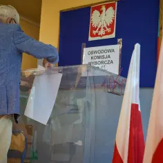 Starszy pan wrzuca kartę do urny. To ważny moment, by wiedzieć, jak głosować.
