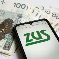 Złotówki i monety obok telefonu z logo ZUS. Planowanie emerytury po mężu.