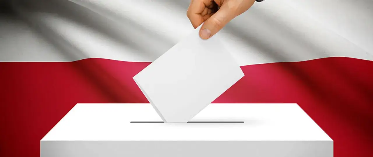 Dłoń wrzuca kartę do urny na tle polskiej flagi. Dowiedz się, jak głosować, by mieć wpływ na przyszłość kraju.