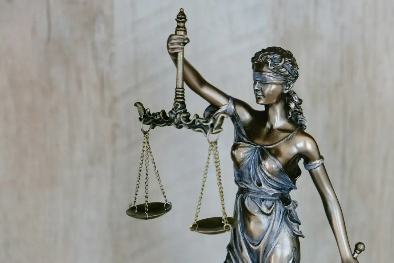 Figurka Temidy z wagą, symbol sprawiedliwości i siły wyższej, która czuwa nad prawem.