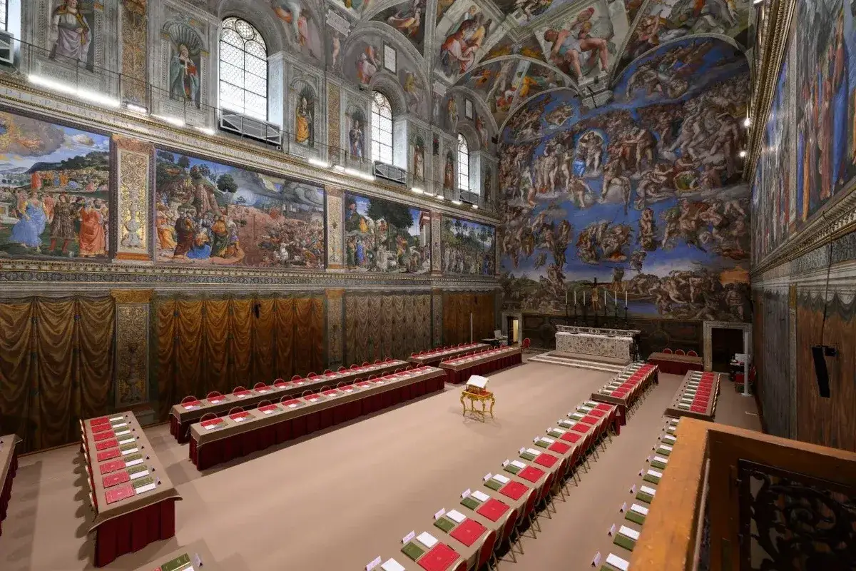 Sala Kaplicy Sykstyńskiej przygotowana do wyboru papieża. Kardynałowie zasiądą przy stołach ozdobionych czerwonymi i zielonymi materiałami, pod freskami Michała Anioła.