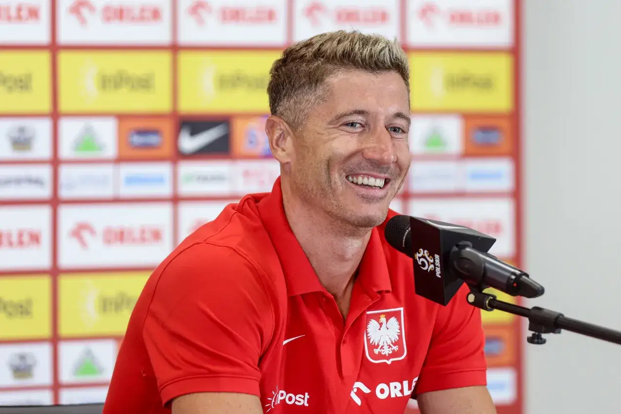 Uśmiechnięty Robert Lewandowski w czerwonej koszulce z orłem. Ciekawe, ile języków zna Robert Lewandowski, by dogadać się z fanami na całym świecie.